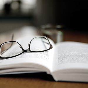 geöffnetes Buch mit einer Brille drauf